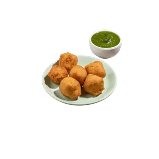A plate of golden-brown fried bondas served with a side of green chutney in a small bowl, isolated on a grey background.