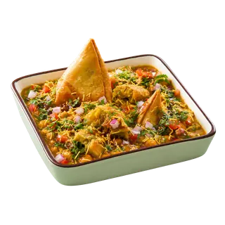 A square bowl of samosa chaat garnished with sev, onions, and tomatoes on a solid grey background.