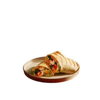 Two halves of a grilled chicken wrap filled with vegetables and chicken, served on a beige plate against a solid grey background.